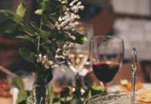 Elegant table setting with floral centerpiece, wine glasses, and gourmet appetizers
